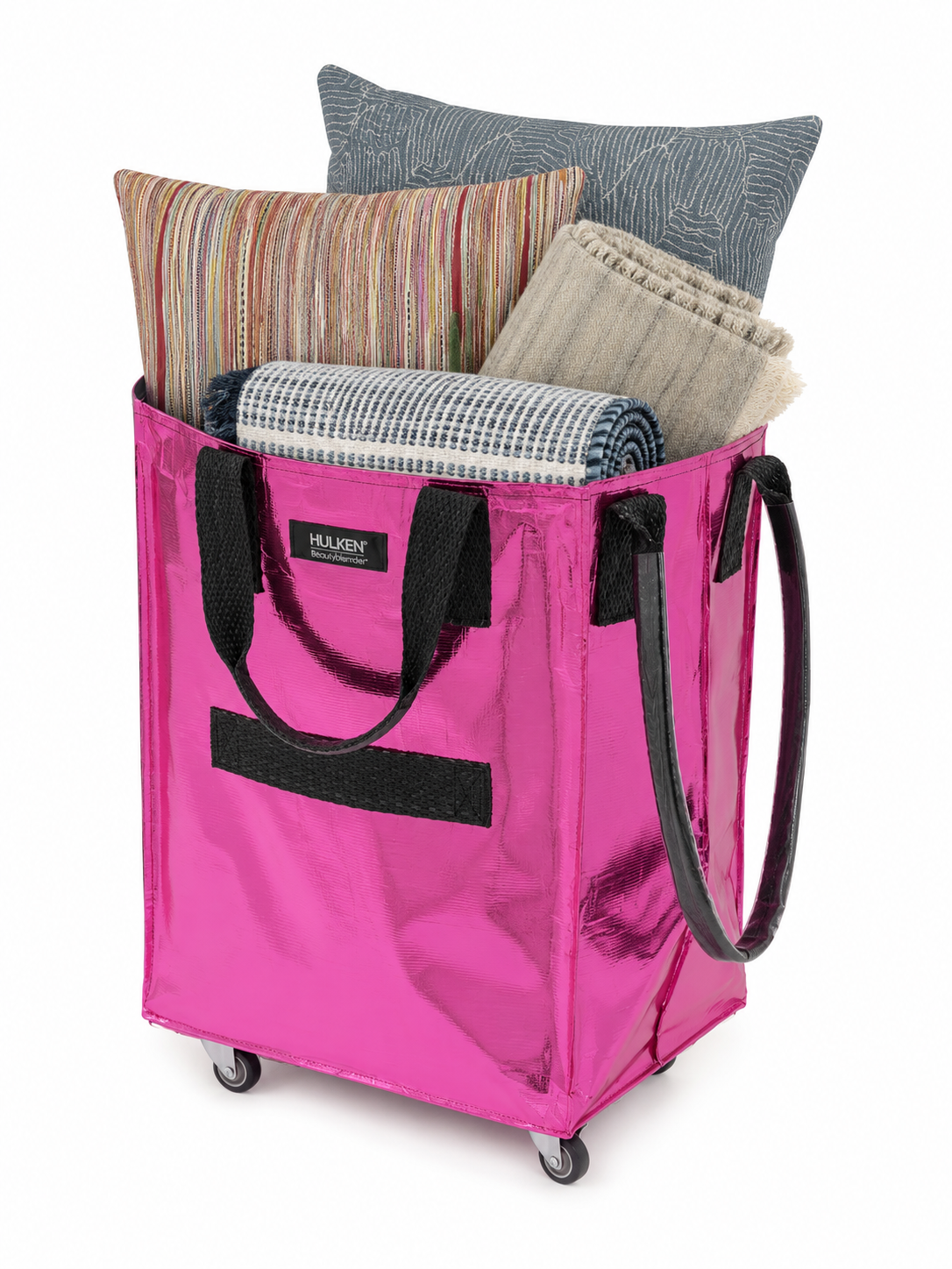 Pink Hulken bag filled with curated bedding, pillows, and textiles for interior design projects